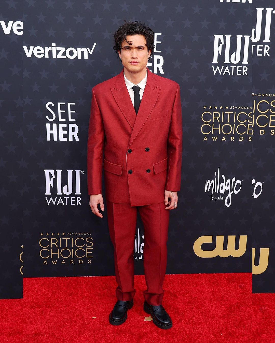 Charles Melton turned heads with his bold and bright choice of attire. The actor accessorized his ensemble with a slim black tie and a pair of hefty black loafers. His sleek and refined appearance was further complemented by his clean-shaven face.