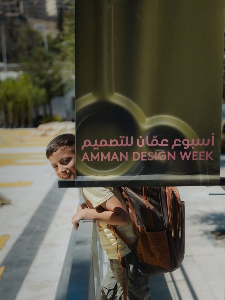 Amman Design Week 2026 banner with a child behind it